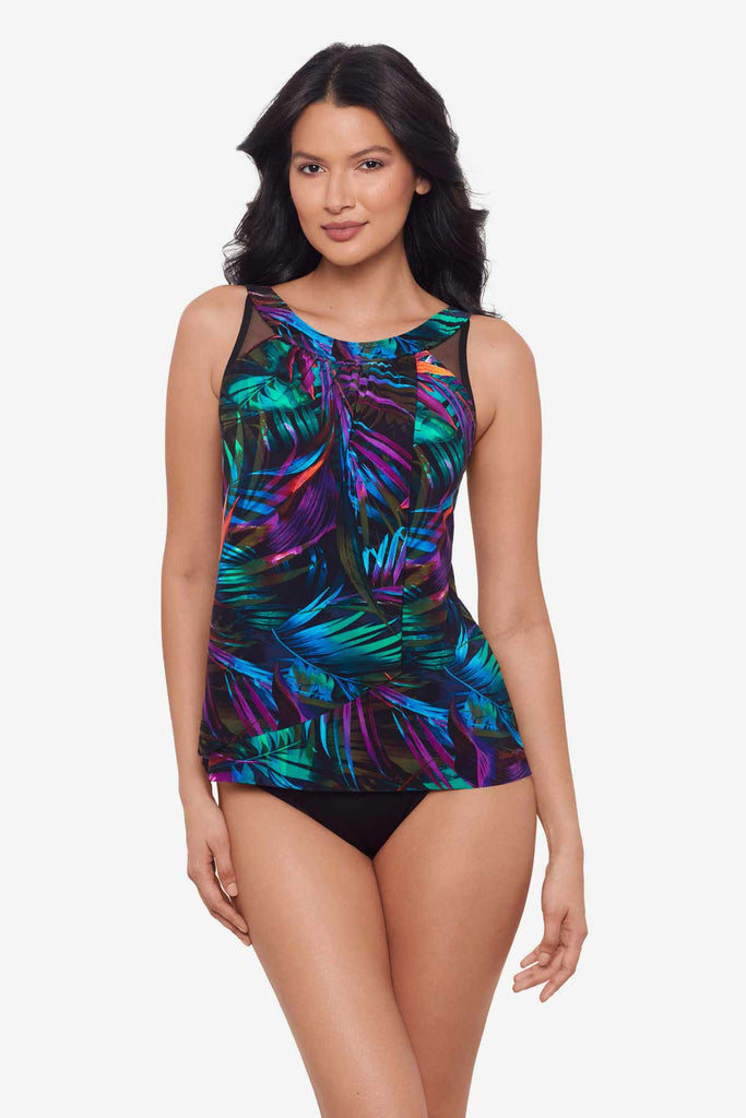 Woman wearing a bright multicolor tankini top with neon palm leaves