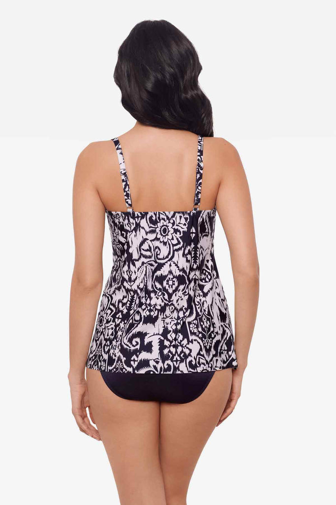 Woman facing away wearing a blue and white tankini top with abstract flowers