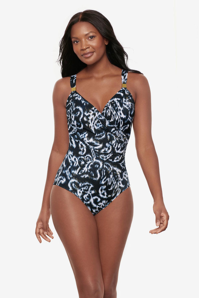 Woman wearing a black and white abstract printed one-piece swimsuit