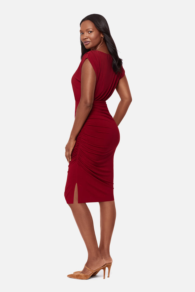 Woman turned left wearing a bright red dress with a high neckline