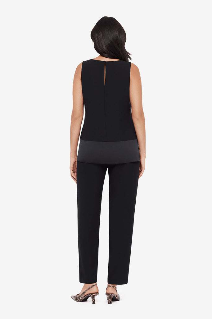 Woman turned away wearing a black tunic blouse with matching jogger pants