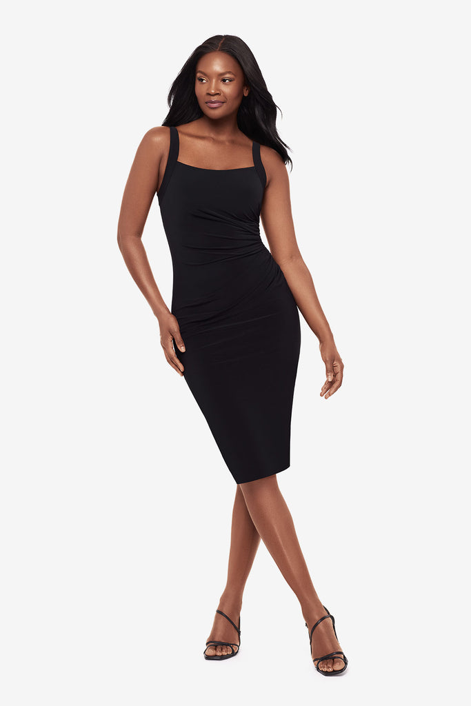 Woman wearing a black midi dress with a square neckline