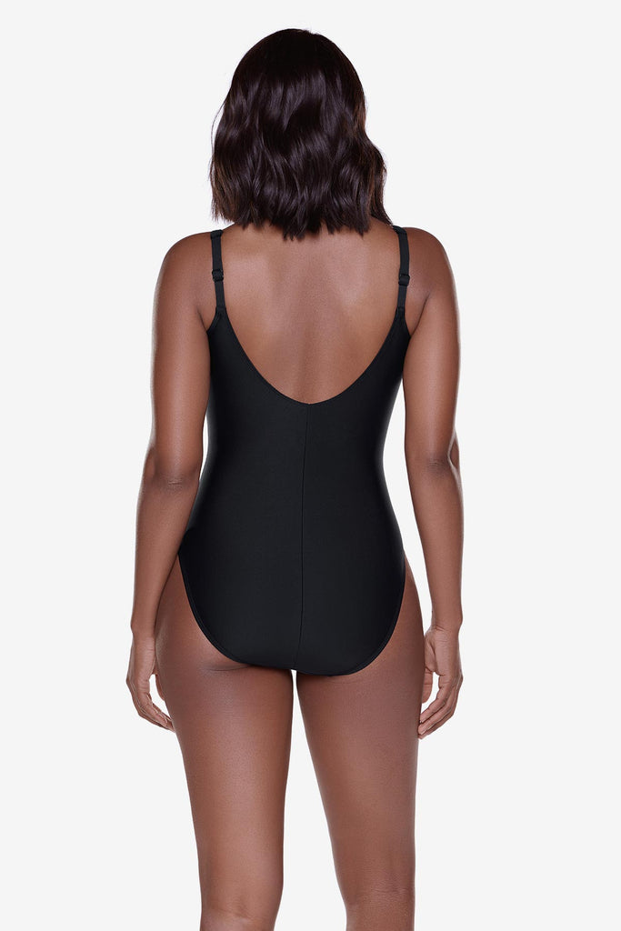 Woman turned away wearing a black one-piece swimsuit 