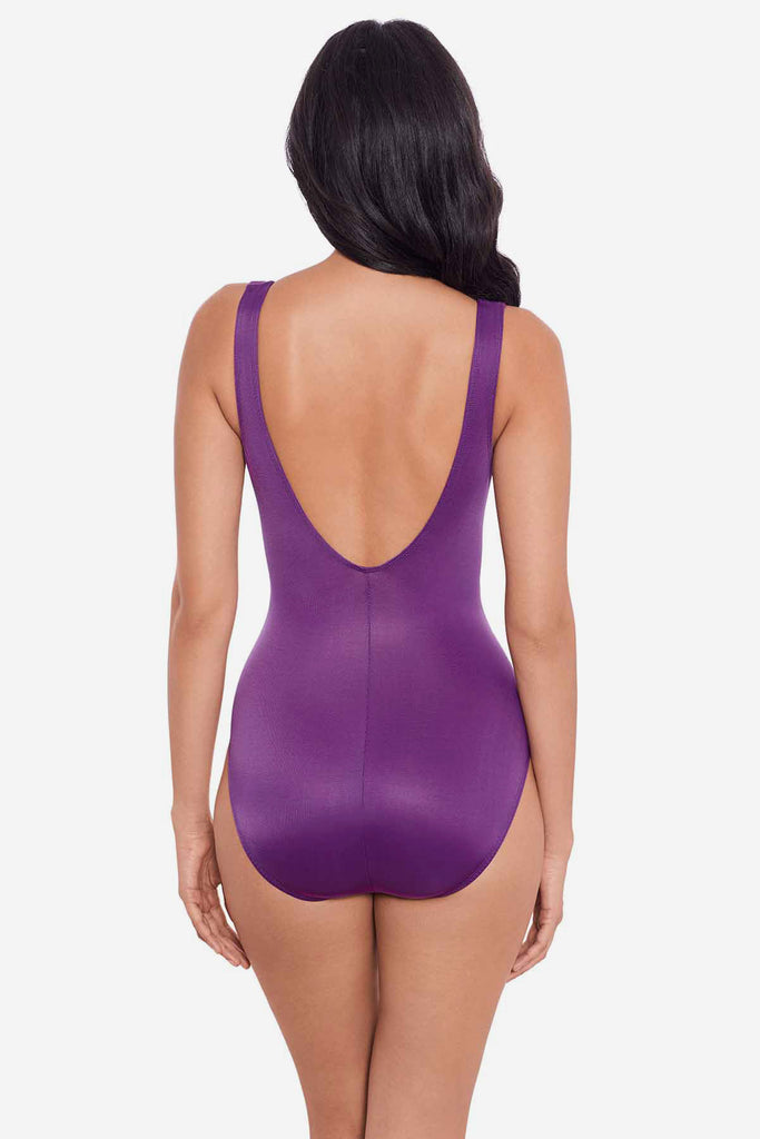 Woman turned away wearing a purple one-piece swimsuit