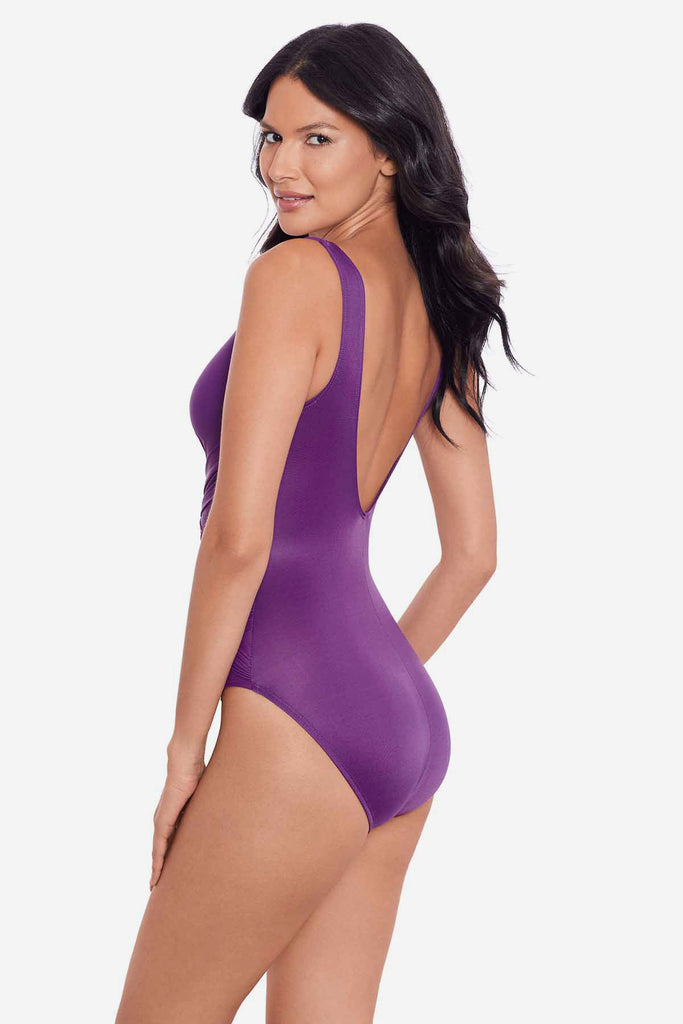 Woman turned left wearing a purple one-piece swimsuit 